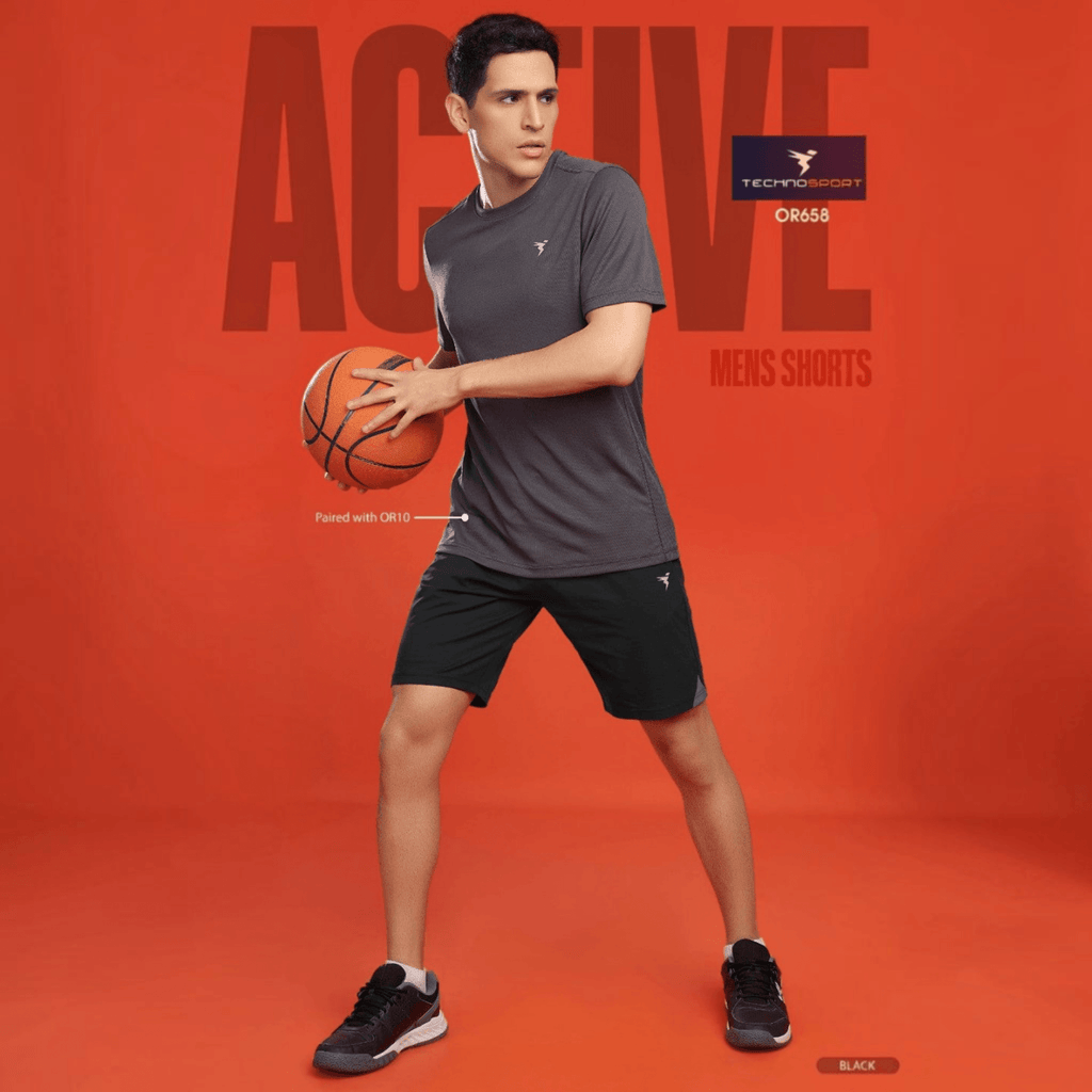 City Center model wearing black Technosport 4-way stretch crispy shorts and a grey t-shirt holding a basketball