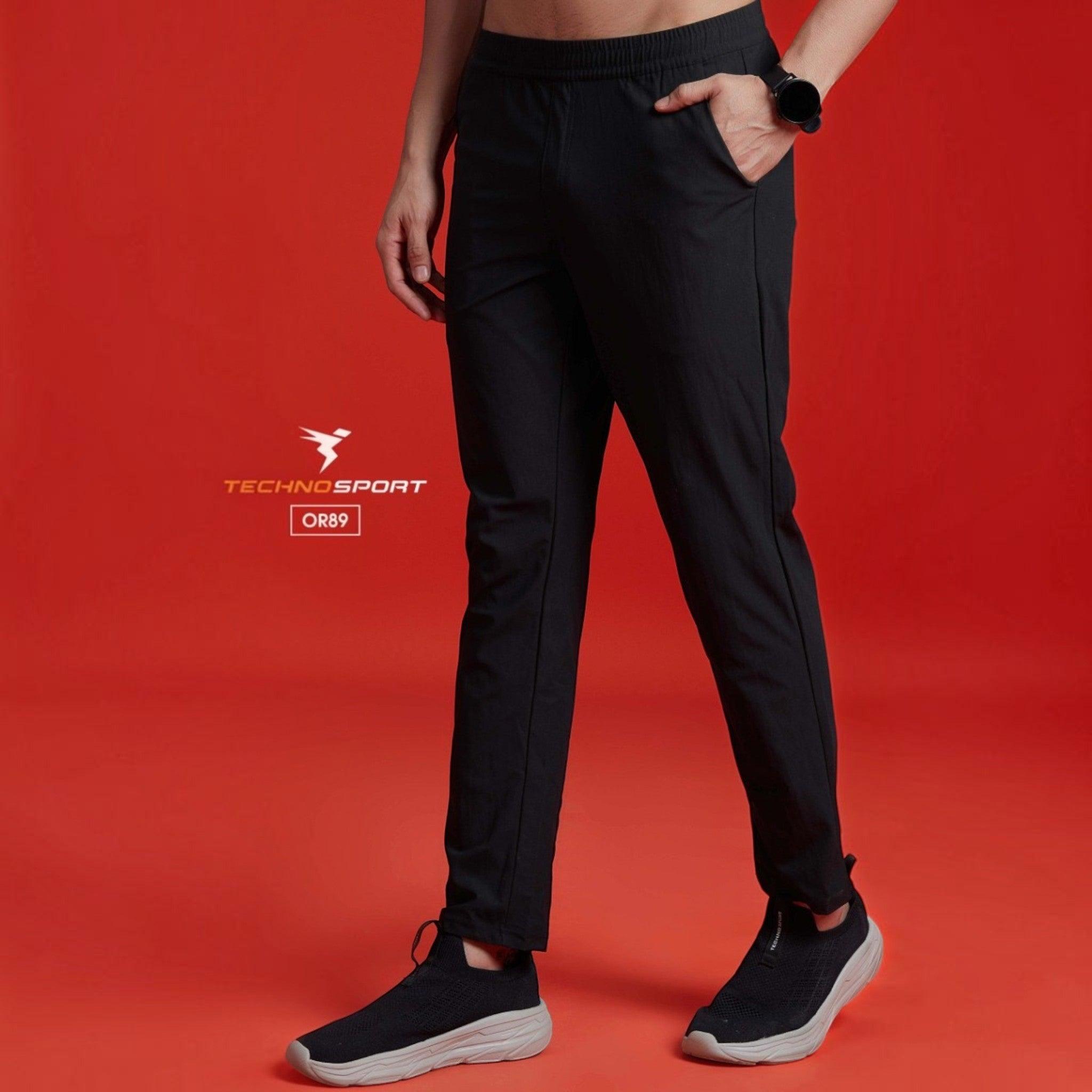 City Center Technosport black 4-way stretch track pant with DuraCool+ technology on a model against a red background