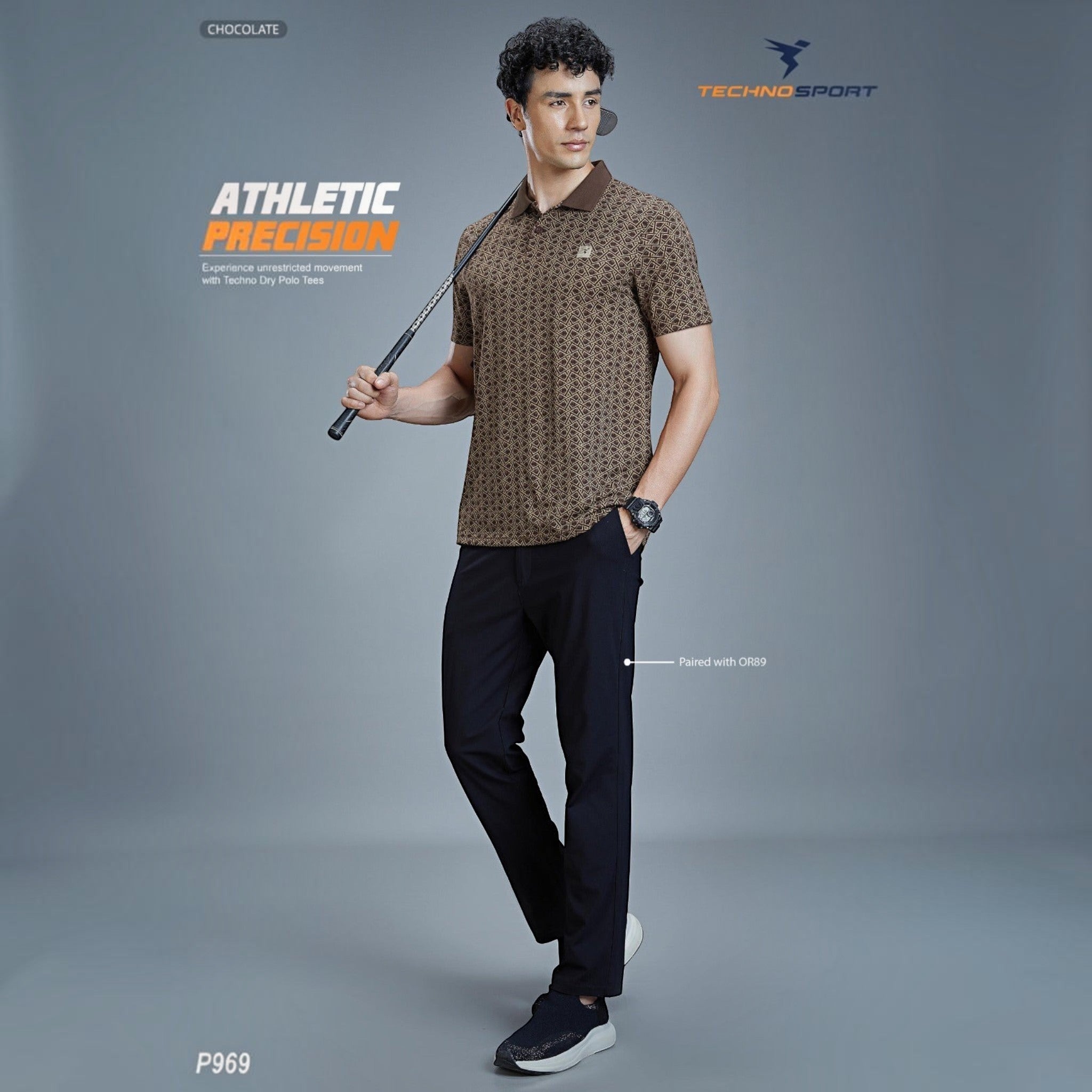 City Center model wearing a chocolate brown Technosport P969 moisture-wicking polo shirt with a geometric pattern.