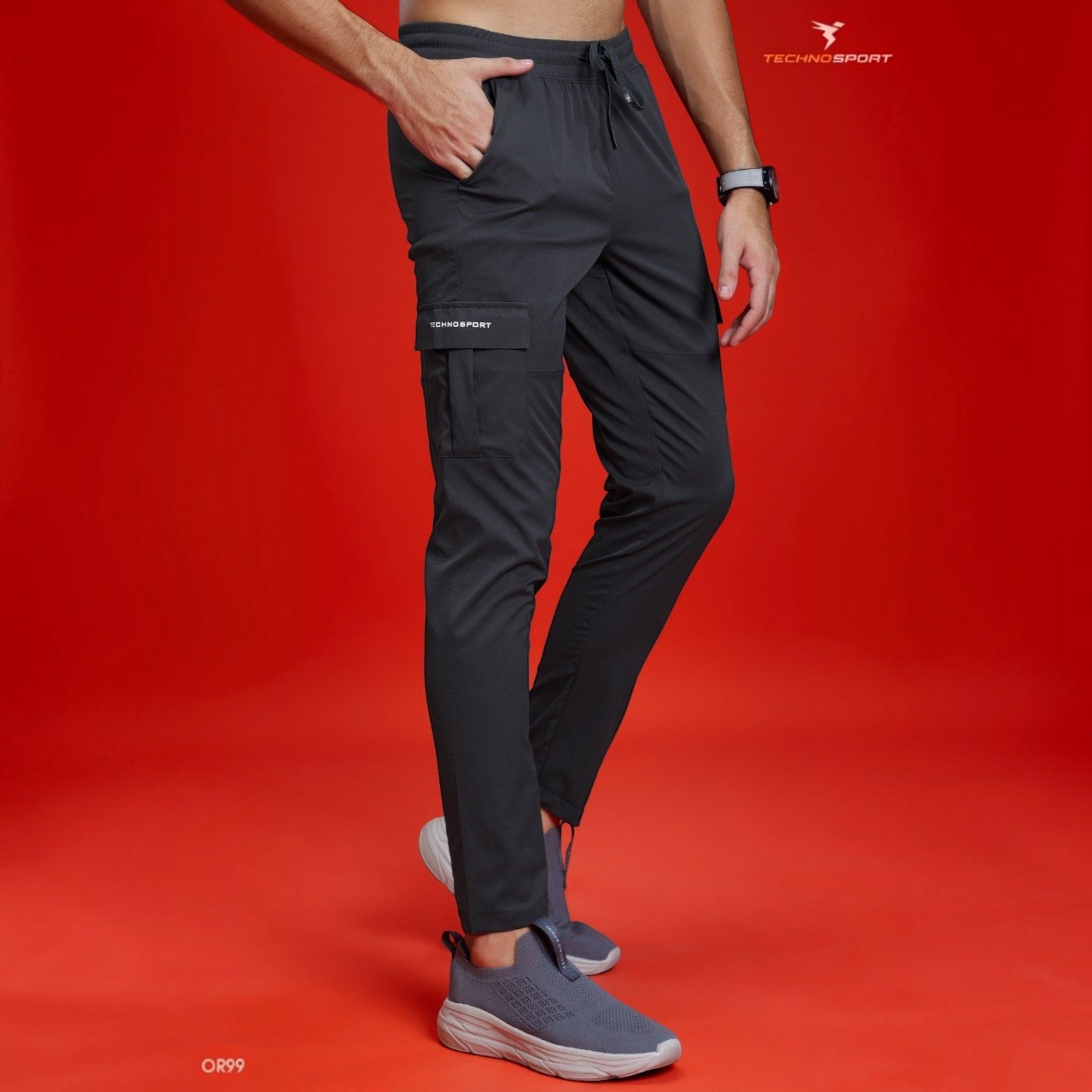 City Center Technosport TS Flexi solid woven charcoal grey cargo pants with side pockets on a model against red background