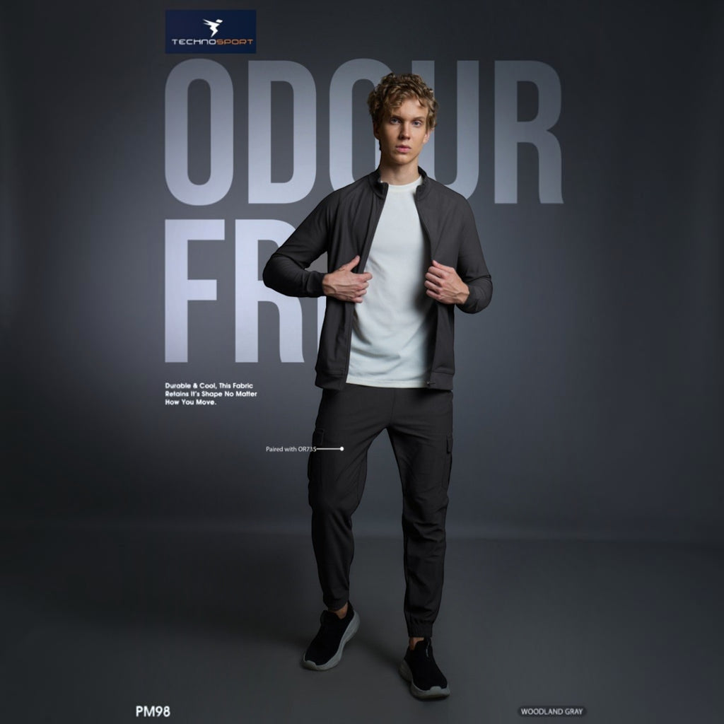 City Center model wearing a charcoal gray Technosport DuraCool+ high-neck jacket with a white t-shirt and joggers.