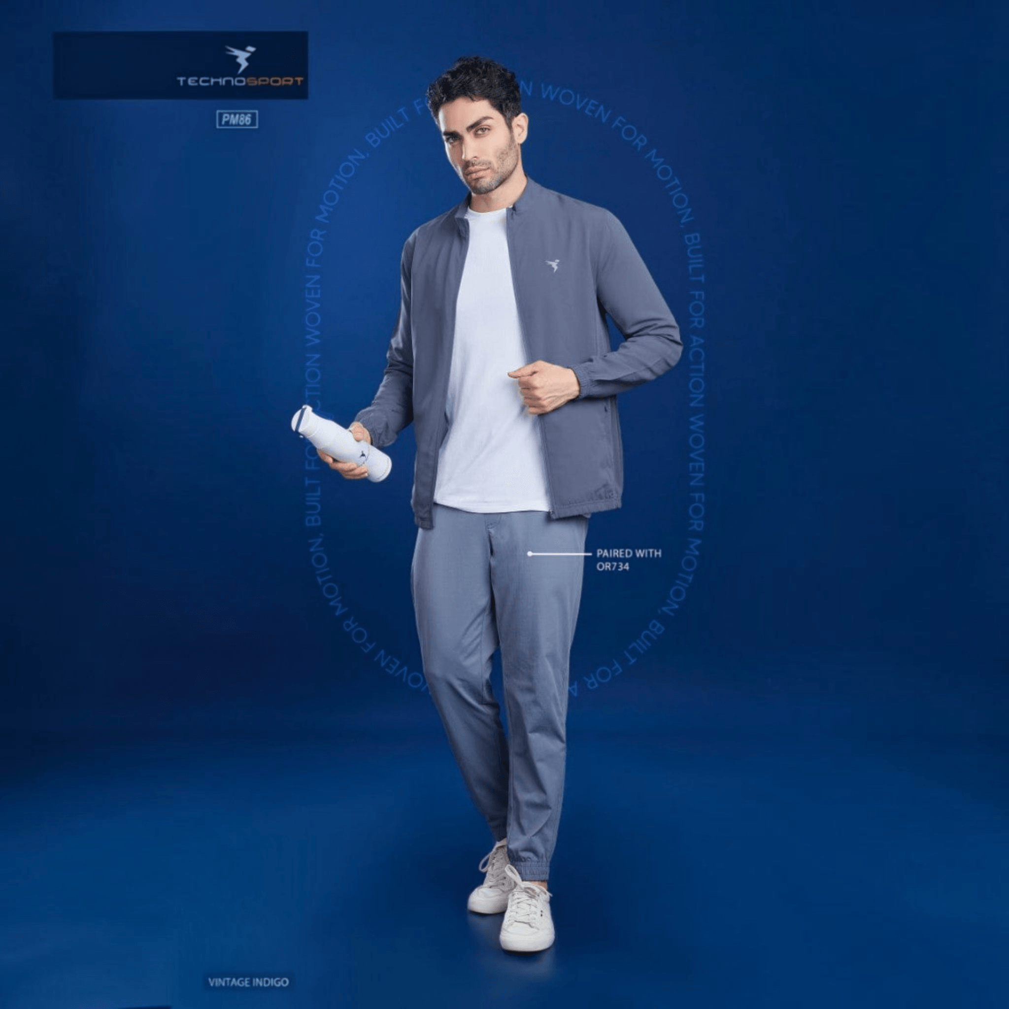 City Center model wearing a grey Technosport TS Flexi Jacket PM86 with a white t-shirt and matching joggers.