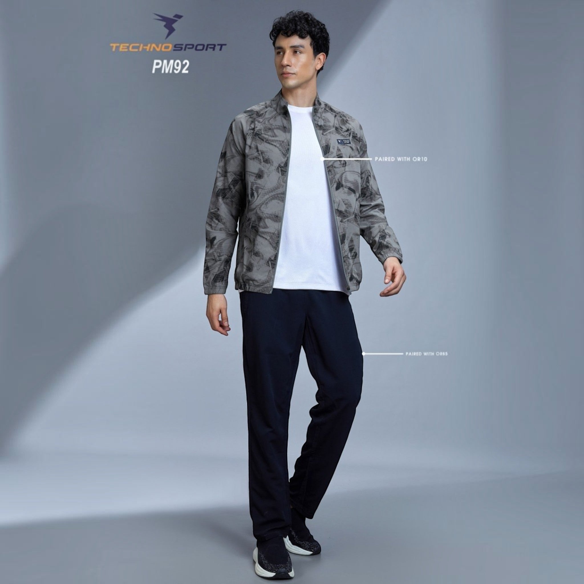 City Center model wearing a grey Technosport all-over print high-neck jacket with full sleeves and odour-free fabric.