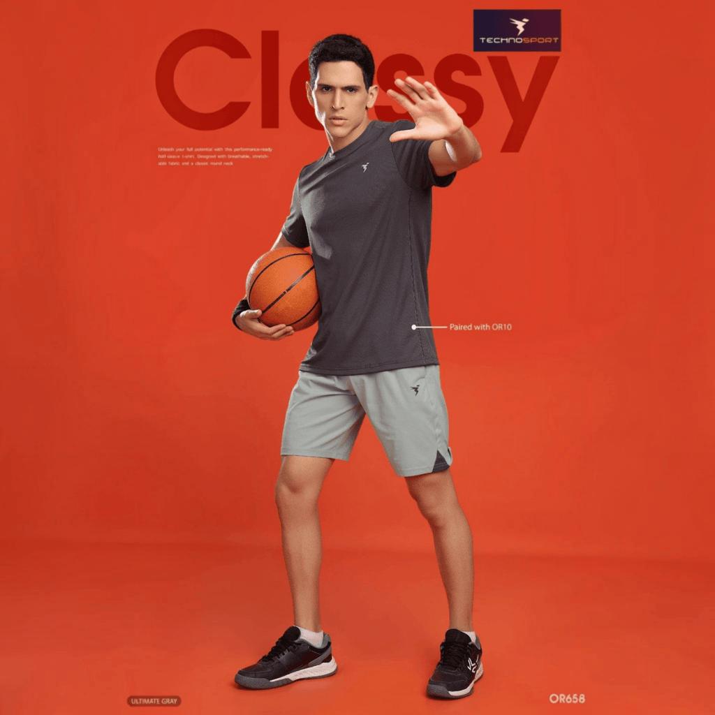 City Center Technosport grey 4-way stretch athletic shorts on a male model holding a basketball against orange backdrop