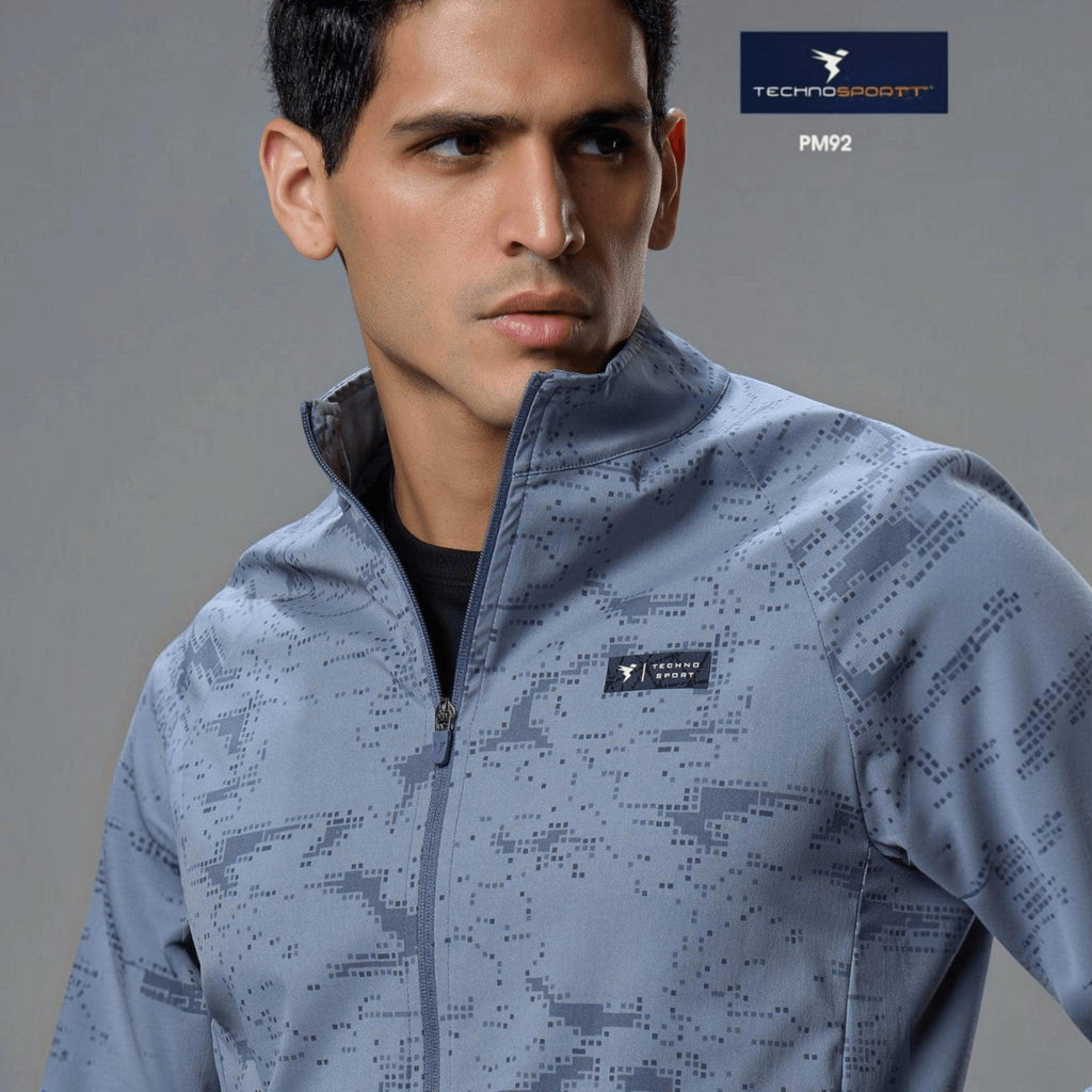 City Center Technosport men's grey hi-neck jacket with all-over pixel print, front zipper, and moisture-wicking fabric.