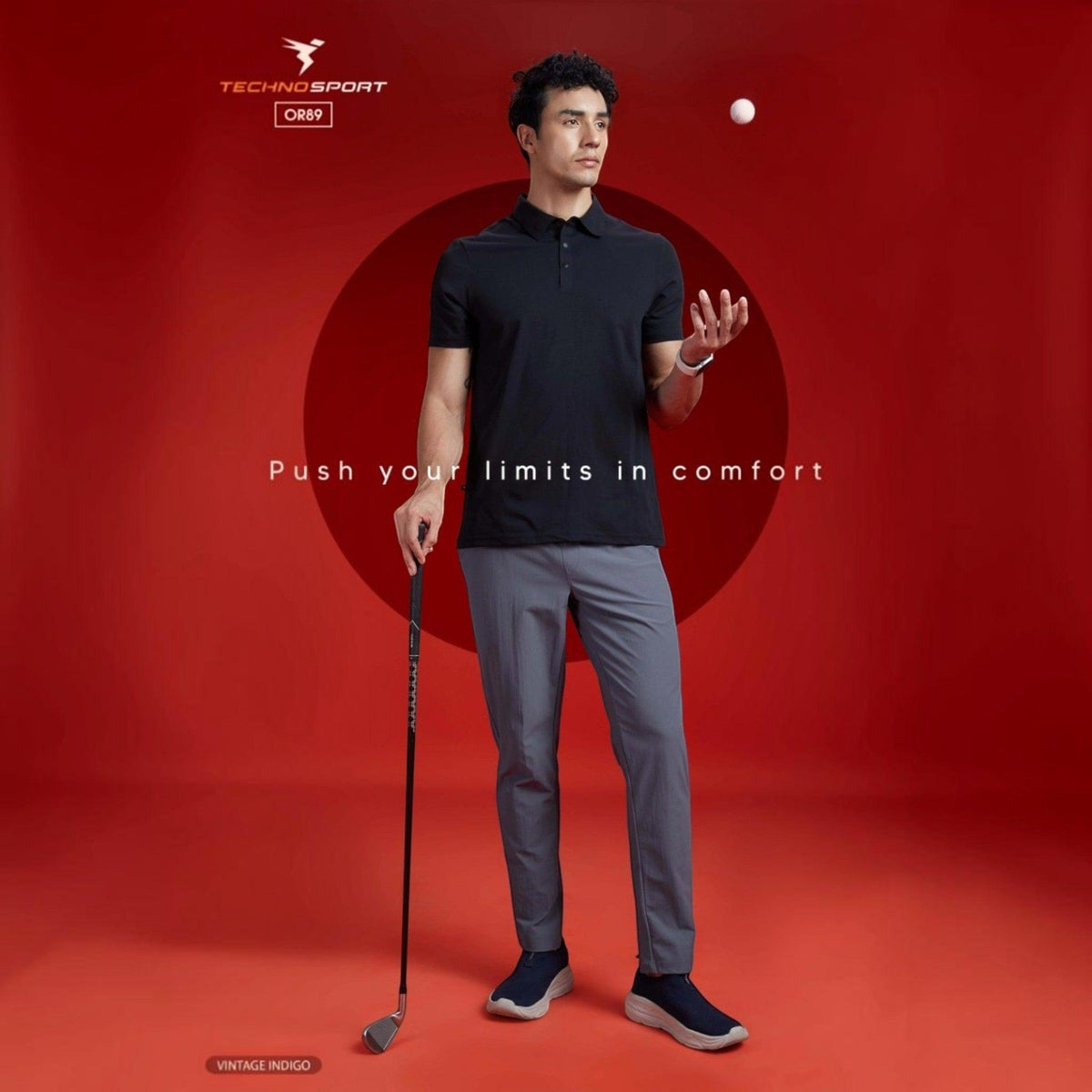 City Center model wearing Technosport DuraCool+ grey 4-way stretch track pants and a black polo shirt on red background