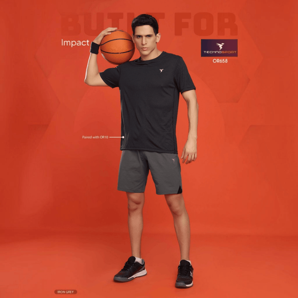 City Center model wearing Technosport iron grey 4-way stretch athletic shorts and a black t-shirt with a basketball