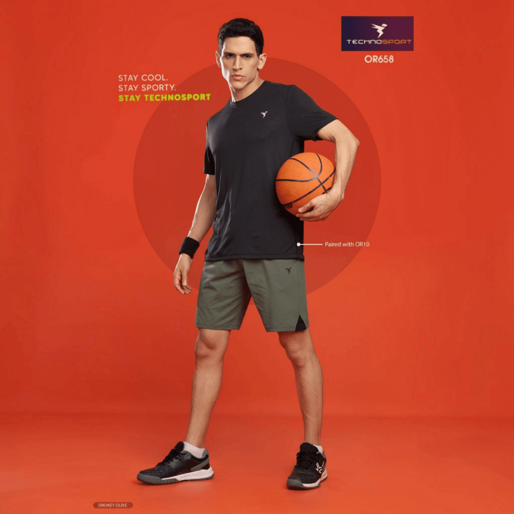 City Center model wearing Technosport olive green 4-way stretch crispy shorts and black t-shirt holding a basketball