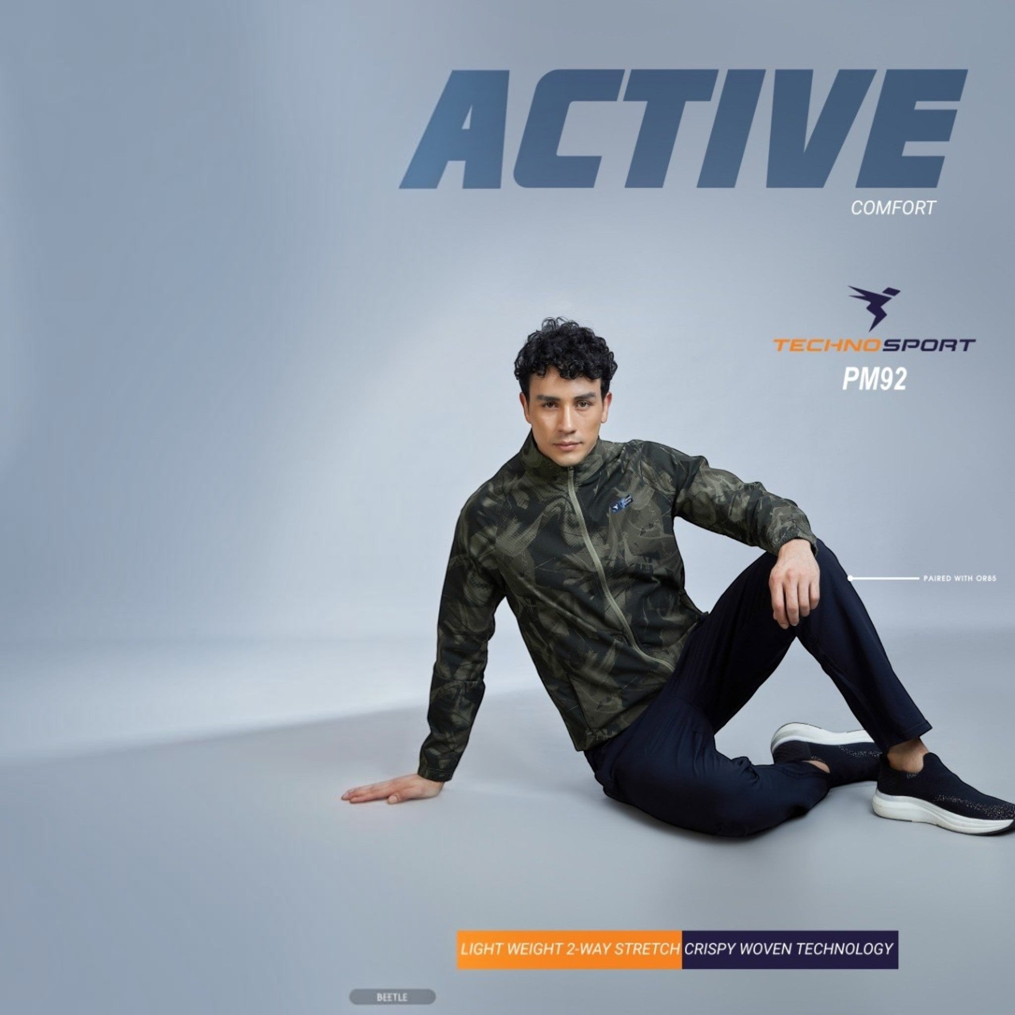 City Center Technosport full-sleeve hi-neck jacket with olive green all-over print worn by a man in a studio setting
