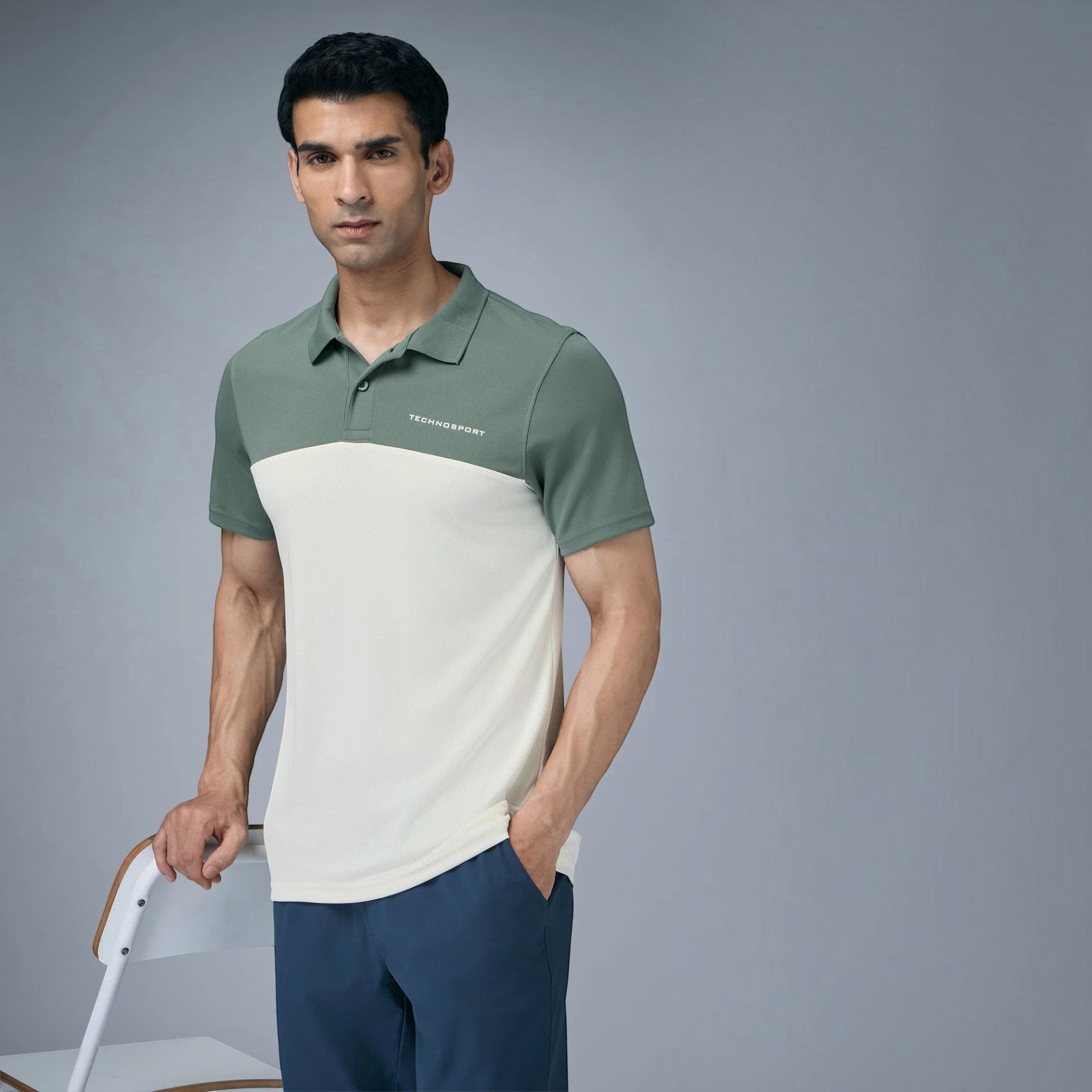City Center model wearing a two-tone off-white and sage green Technosport performance collar neck t-shirt
