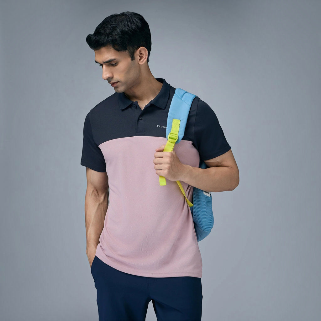 City Center Technosport performance polo shirt in navy and light pink with a blue backpack on a male model
