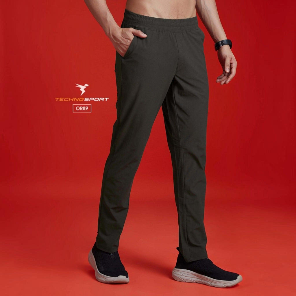 City Center Technosport DuraCool+ solid dark grey 4-way stretch track pants worn by a man against a red background.