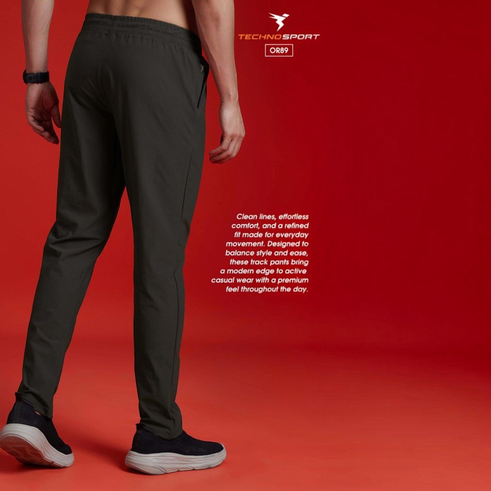 City Center Technosport DuraCool+ solid dark grey 4-way stretch track pants worn by a model against a red background.