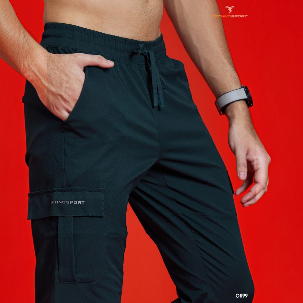 City Center Technosport TS Flexi solid woven cargo pants in dark green with side pockets on a model against red