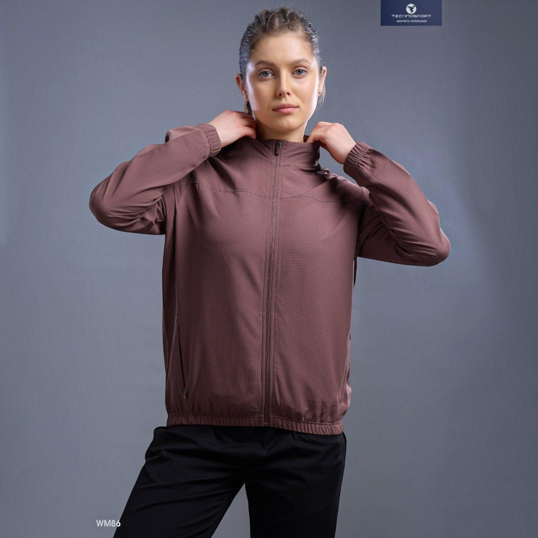 City Center Technosport WM86 brown zip-up athletic jacket with a hood worn by a woman against a grey background