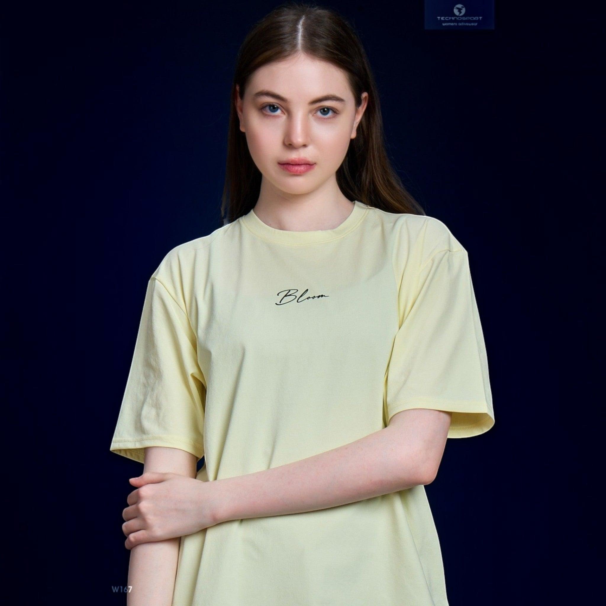City Center Technosport women's pale yellow crew neck t-shirt with Bloom script graphic on a model