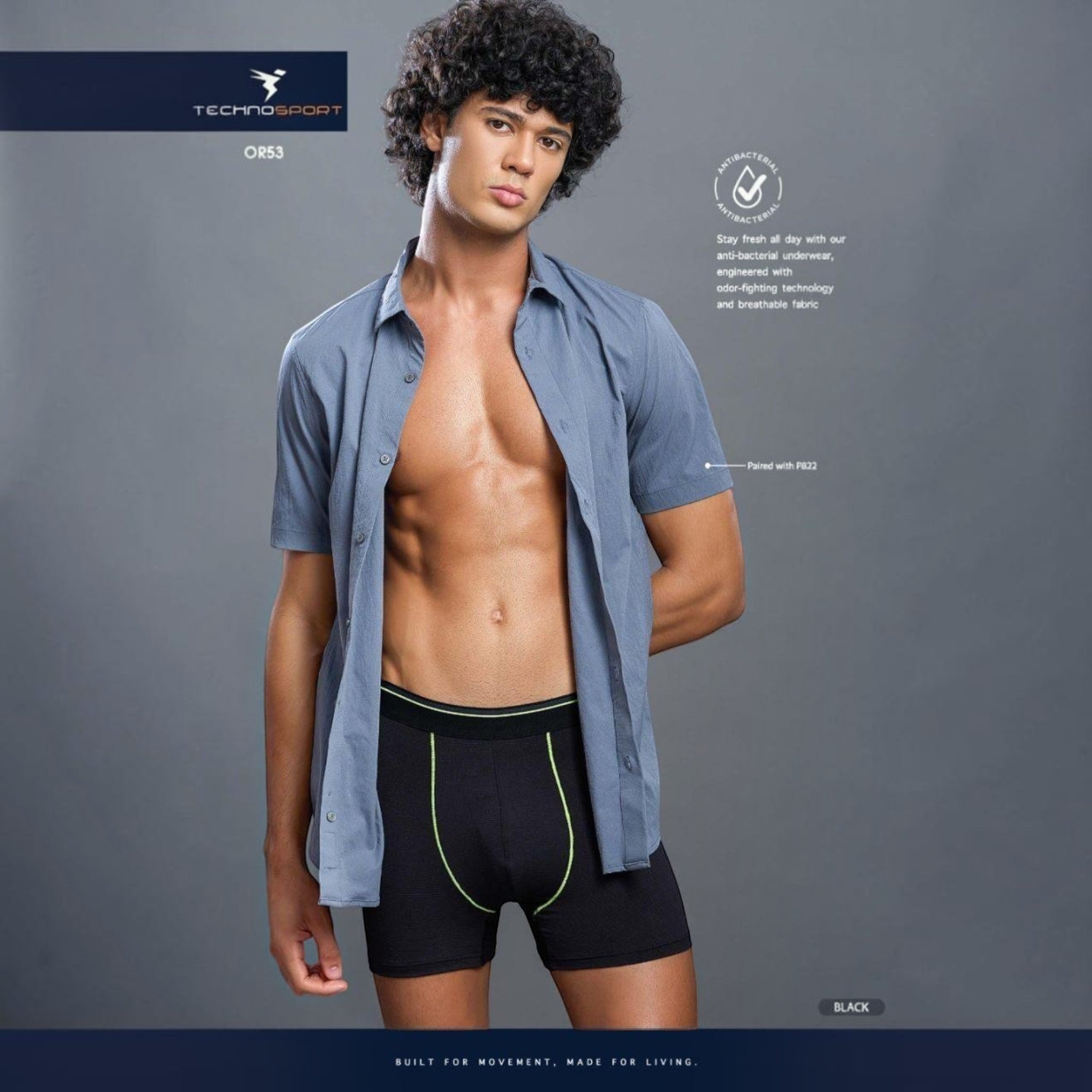 City Center model wearing black Technosports OR53 athletic trunks with neon green stitching and 4-way stretch mesh