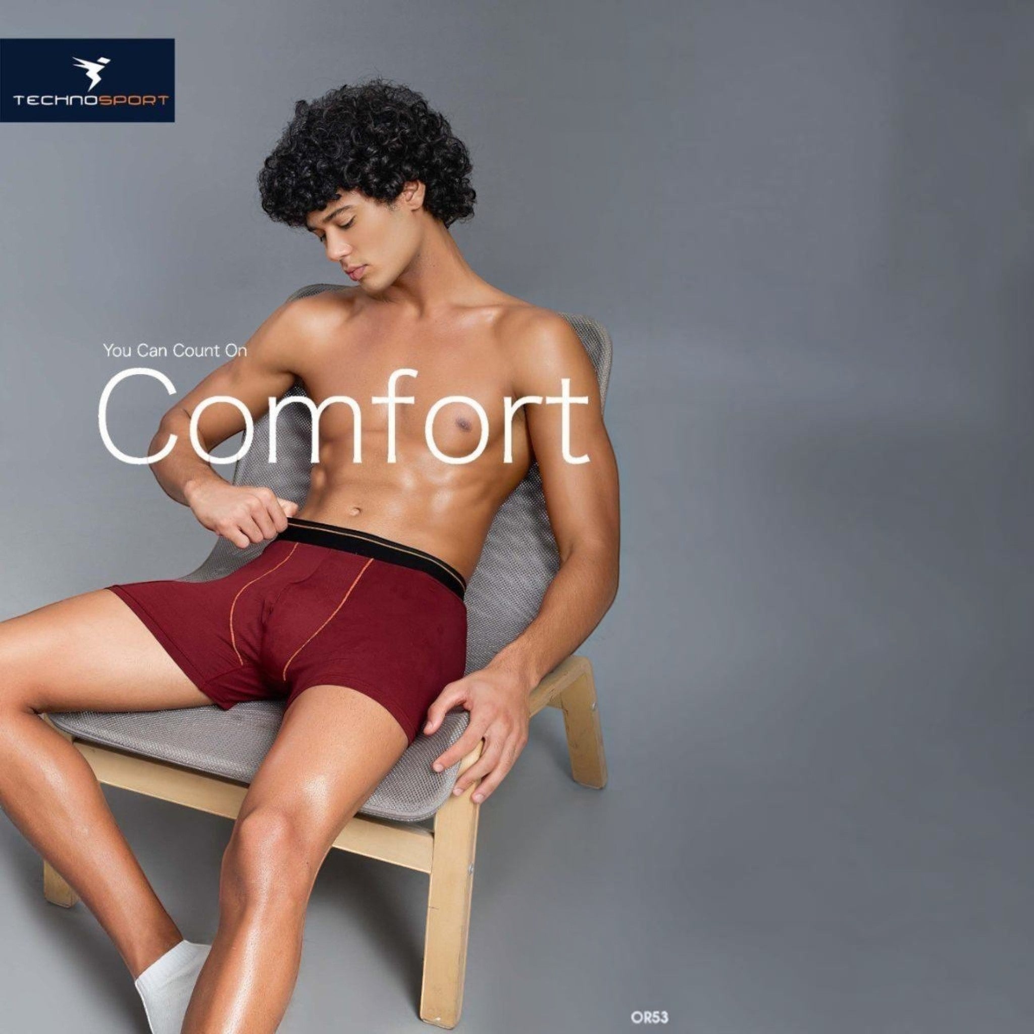 City Center Technosports OR53 maroon athletic trunk with 4-way stretch mesh fabric worn by a model on a chair