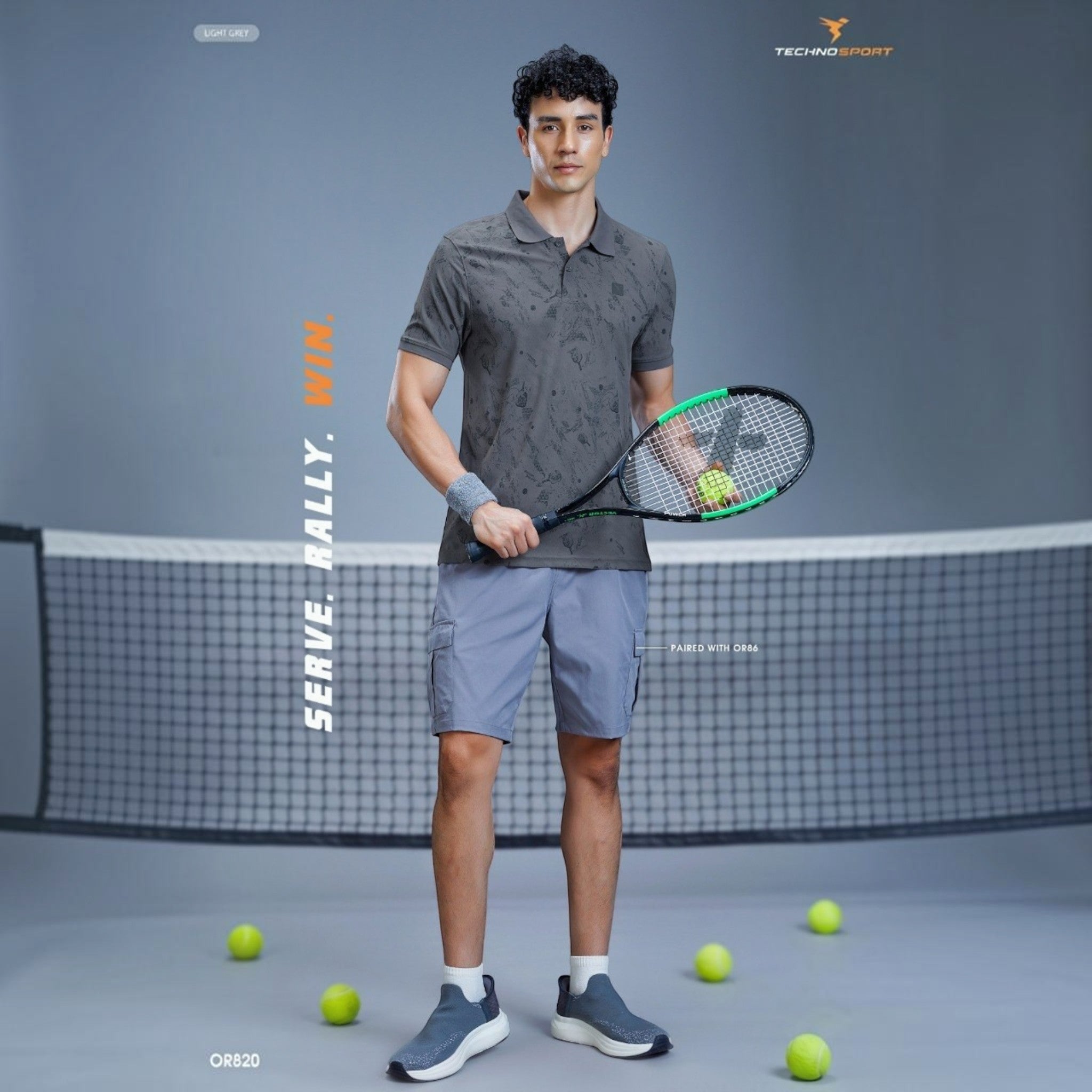 City Center TECHNOSPORTS OR820 performance polo shirt in grey with tennis racket on a court setting