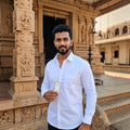 A man wearing a City Center TruWhite by SPEED white formal cotton button-down shirt standing in front of a temple.