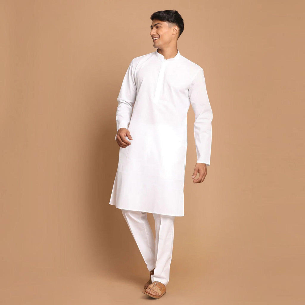 Man wearing a City Center white cotton kurta pyjama set for festive occasions, standing against a beige background.