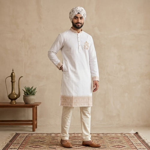 City Center white cotton kurta with gold Ganesha embroidery, worn by a man in a turban and cream trousers.
