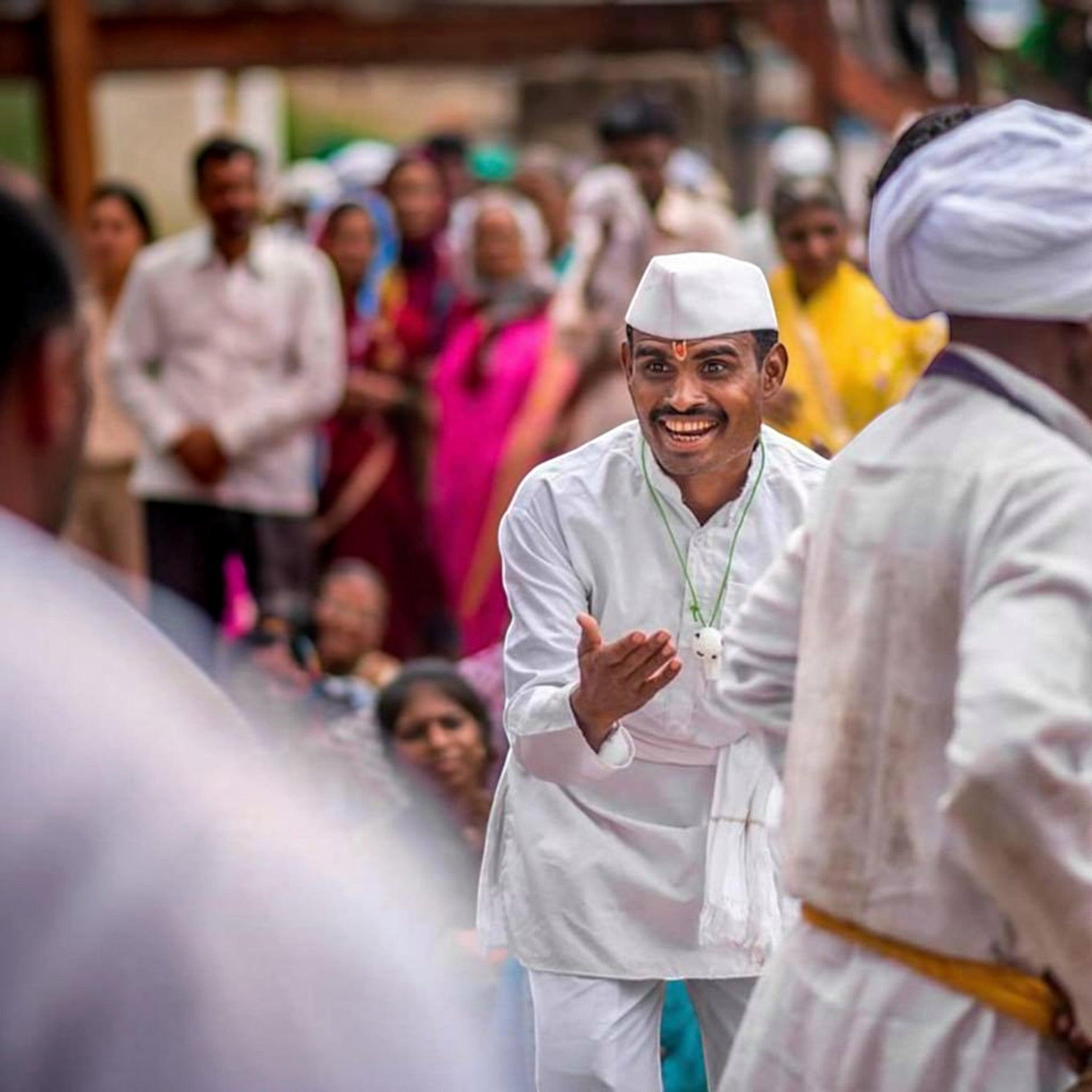 Man wearing a City Center white cotton kurta pyjama and traditional cap during a festive cultural celebration