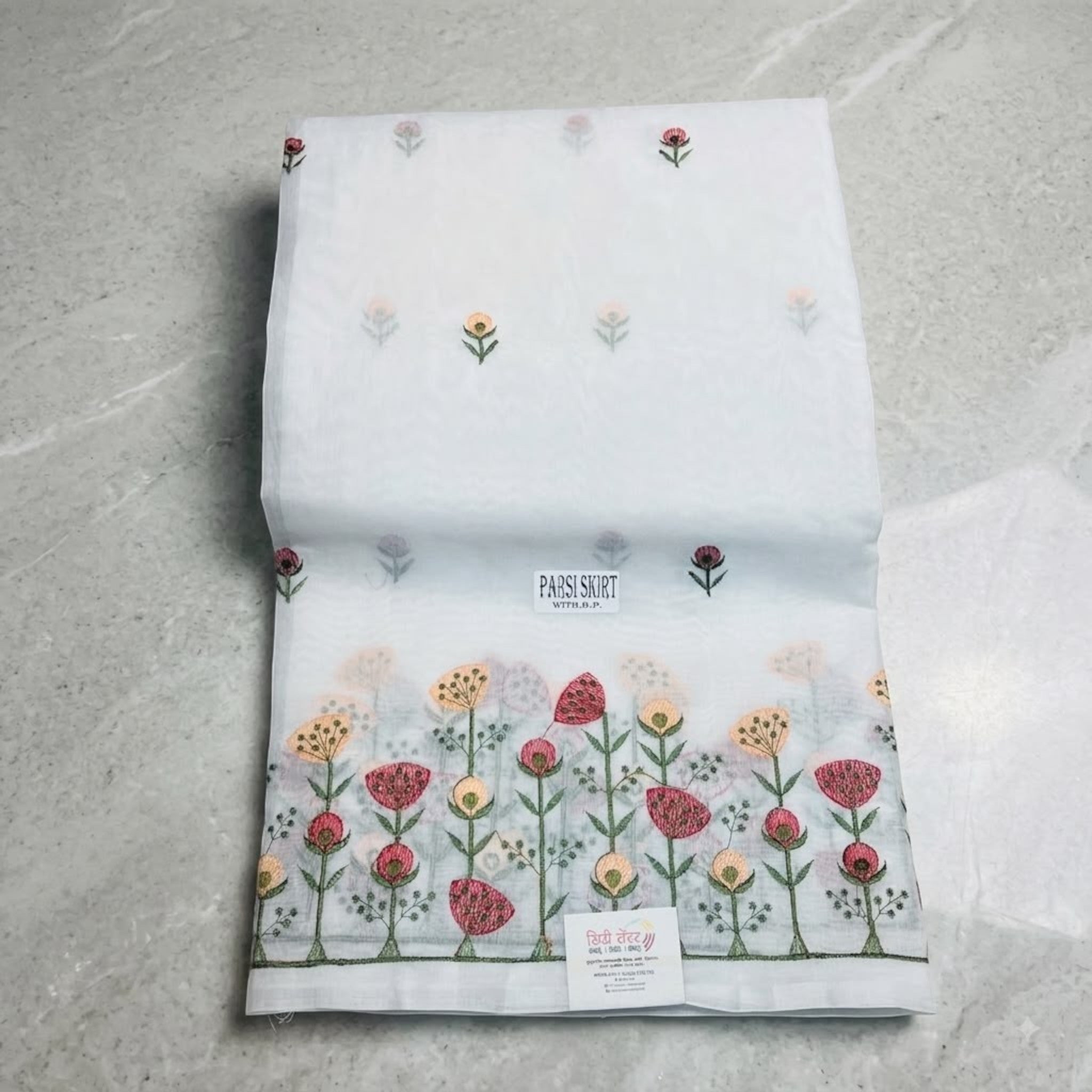 City Center white Parsi skirt saree featuring delicate floral Gara embroidery with pink and orange threadwork motifs.