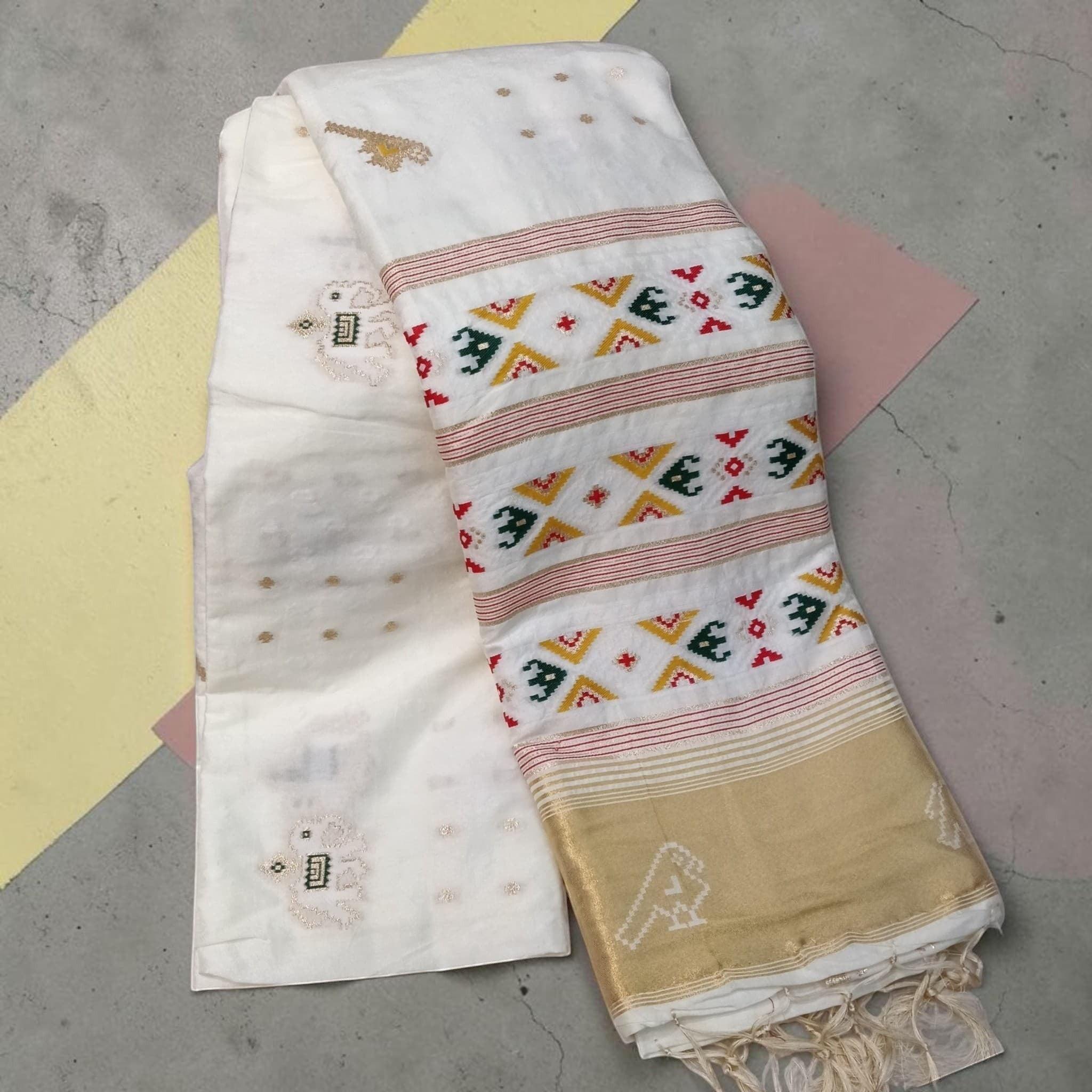City Center white silk cotton saree with traditional Patola-inspired geometric motifs and a gold zari border