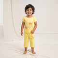 City Center kids honey girl co-ord set featuring a yellow short-sleeve top and matching cropped pants with prints