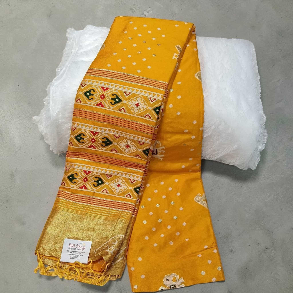 City Center yellow silk cotton saree featuring traditional Patola geometric patterns and a gold zari border.