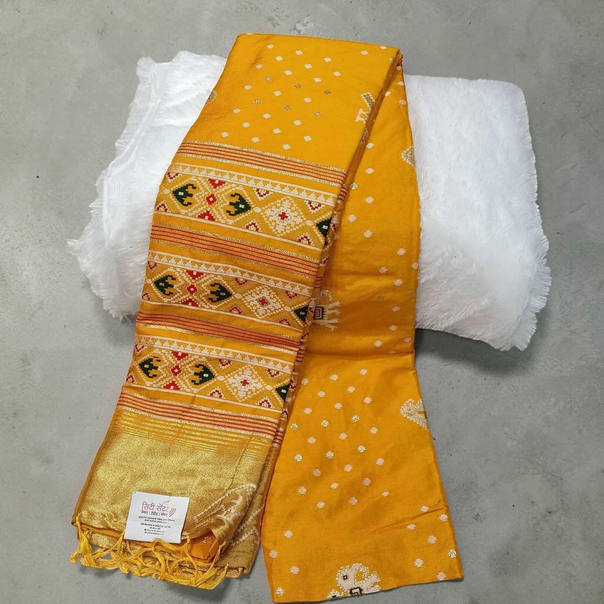 City Center yellow silk cotton saree featuring traditional Patola geometric patterns and a gold zari border.