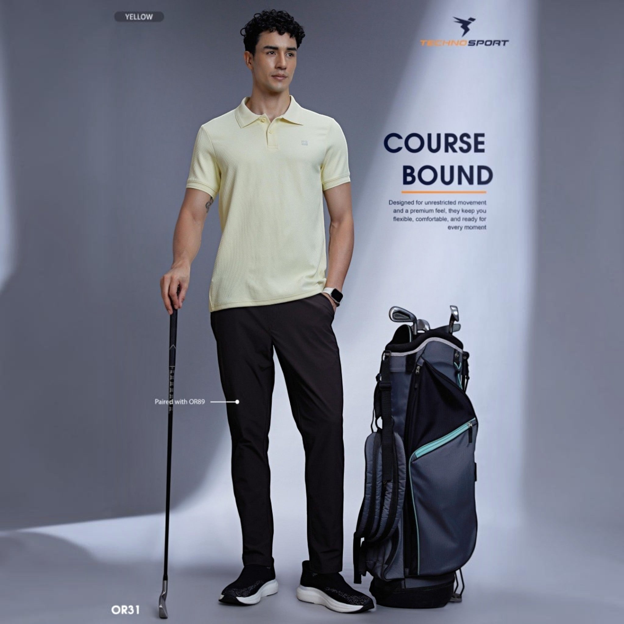 City Center OR31 premium yellow polo shirt worn by a male golfer with dark trousers and a golf bag in a studio