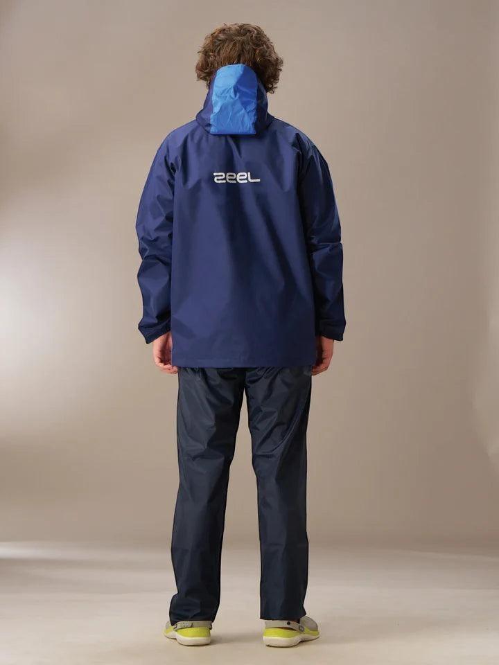 City Center Zeel Go Hike black and blue waterproof rainsuit with hood, worn by a man from the back view.