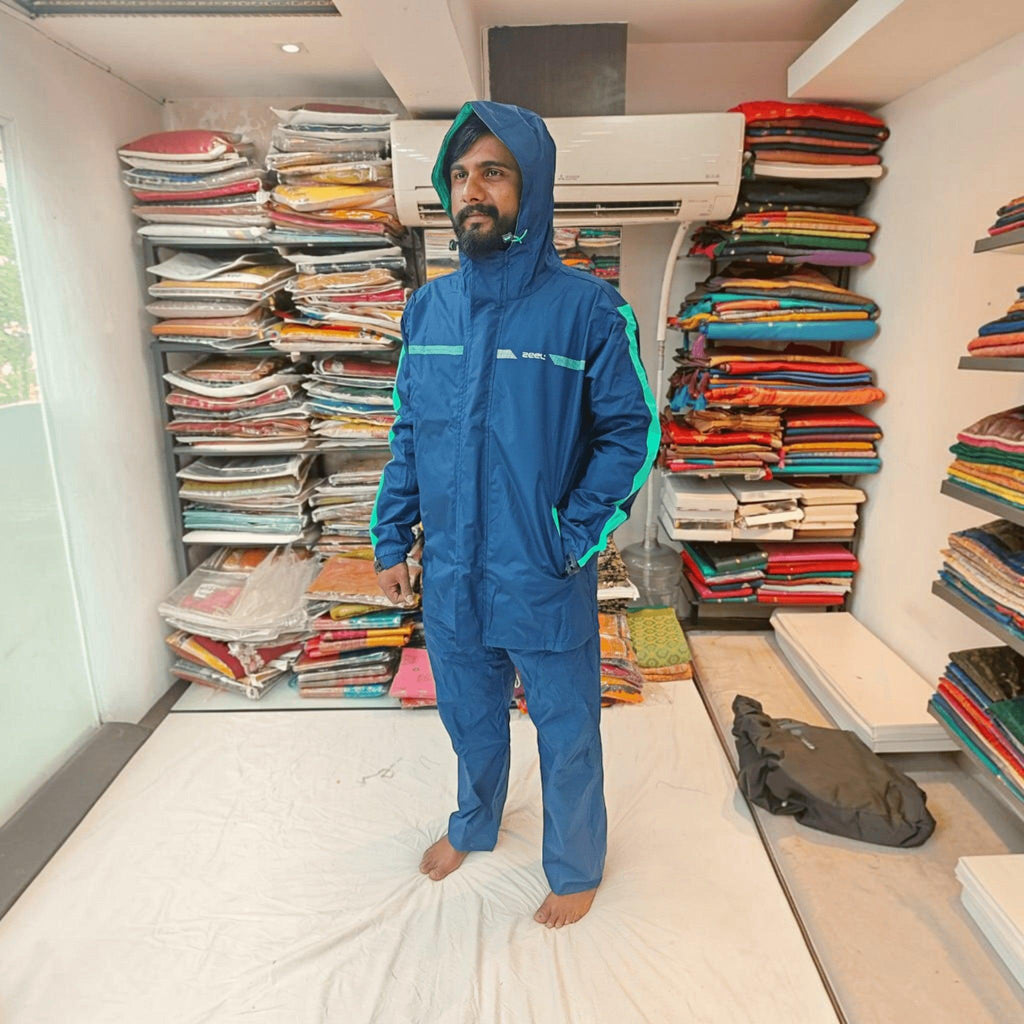 City Center ZEEL premium blue waterproof rainsuit with hood and green accents worn by a man in a retail store