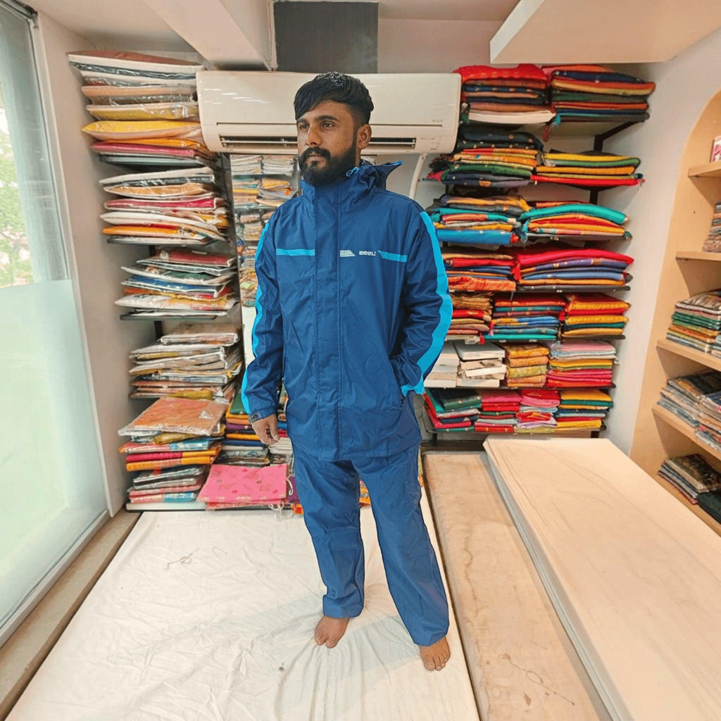 City Center ZEEL premium blue and black waterproof rainsuit with hood and full zipper worn by a man in a shop
