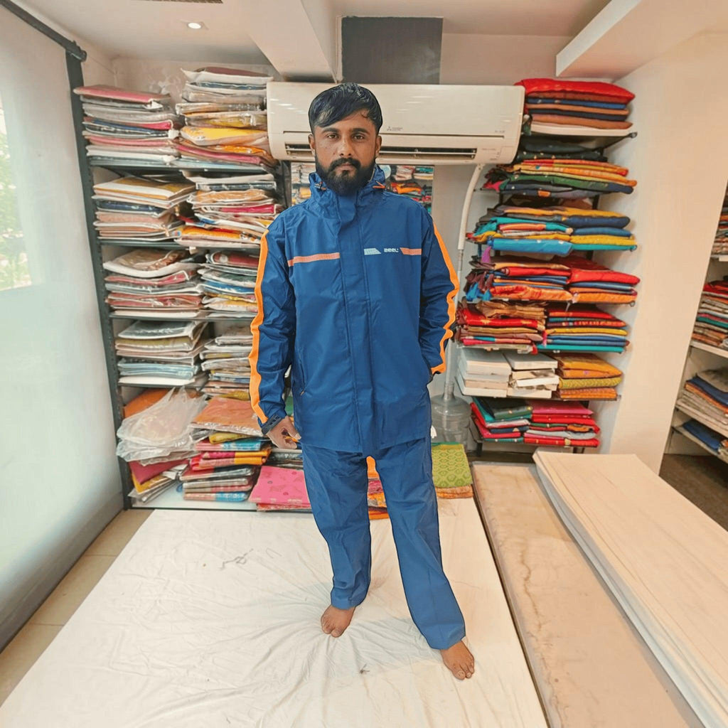 City Center ZEEL premium blue waterproof rainsuit with orange side stripes worn by a man in a retail store setting