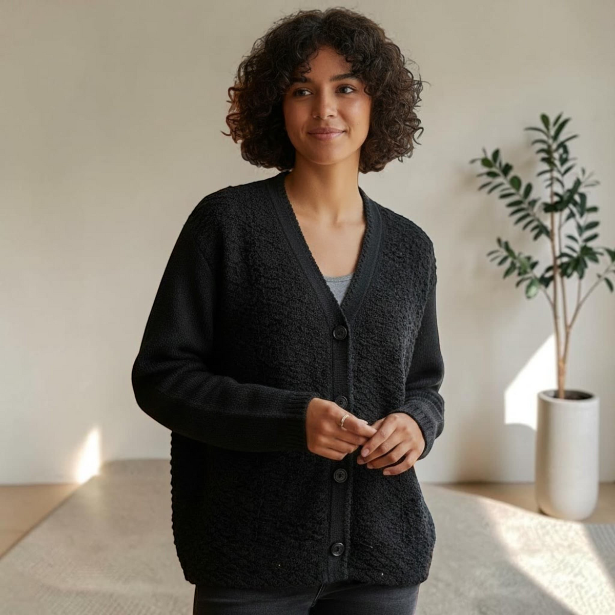 City Center woman wearing a black textured V-neck button-up cardigan sweater with a soft lightweight knit finish